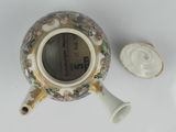 a small vase with a lid sitting on a table