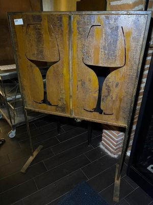 two wine glasses painted on the side of a wooden cabinet