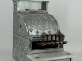 an old fashioned cash register sitting on a white surface
