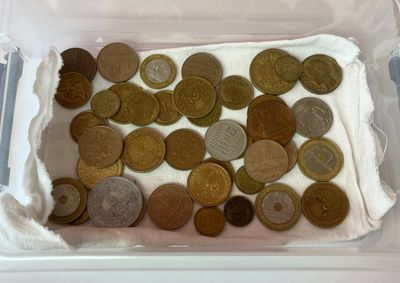 beaucoup de pièces de monnaie dans un récipient en plastique posé sur une table