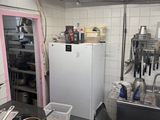 a kitchen with a refrigerator, stove, sink, and other items on the counter