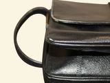 a black purse that is sitting on top of a table