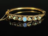 a gold bracelet with oplites and diamonds