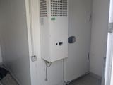 a small room with a refrigerator and a chair in it