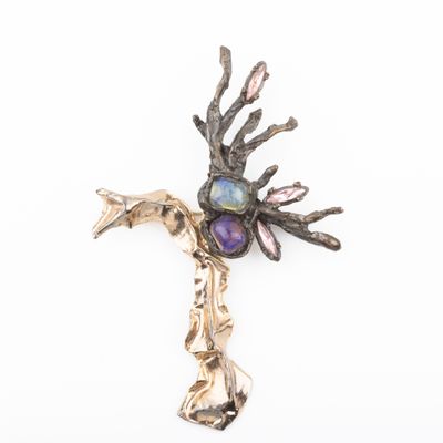 a close up of a metal cross with a bird on it