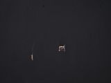 an airplane flying in the dark sky with two people on it
