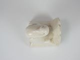 a small statue of a fish on a white surface