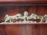 a wooden cabinet with a lion and lion figurine on it