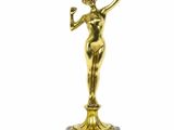 une statue en or représentant une femme tenant un verre à la main
