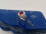 un gros plan d'une bague ornée d'une pierre rouge posée sur une pierre bleue