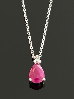 un gros plan d'un collier avec une pierre rose suspendue à une chaîne