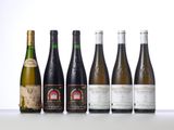 six bottles of wine are lined up on a table