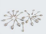 several silver spoons arranged in a circle on a white surface