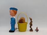 toy figurines of a man with a basket and a teddy bear