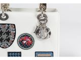 a white purse with a bunch of patches on it