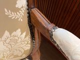 a close up of the arm of a chair with a white cloth on it