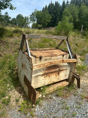 une vieille caisse en bois posée au milieu d'un champ