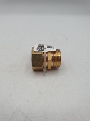un gros plan d'un raccord en laiton sur une surface blanche
