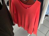 a lot of clothes hanging on a rack in a store
