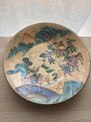 a plate with a painting on it sitting on a table