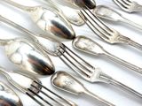 beaucoup de cuillères et de fourchettes en argent sur une table