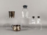 trois bocaux en verre et une coupe en argent posés sur une table
