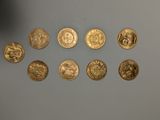 Plusieurs pièces d'or sont alignées sur une table