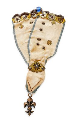 an image of a very old looking broochle with a blue and white ribbon