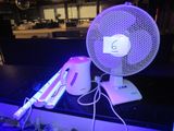 a fan sitting on top of a counter next to a remote control