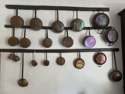 many pots and pans hanging on the wall