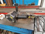a drill on a table in a workshop with other tools