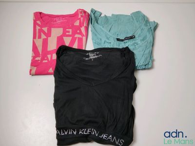 three t - shirts sitting on top of a white table next to each other