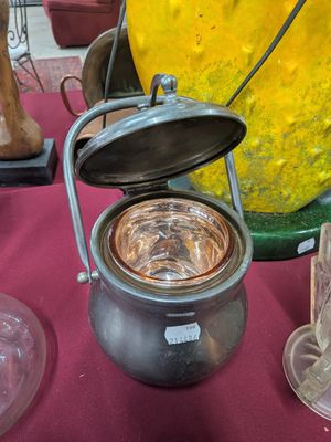 une casserole avec un couvercle posée sur une table à côté d'autres objets en verre