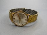 an image of a gold watch with a white face on a table