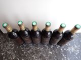 six bottles of wine are lined up in a row on a table