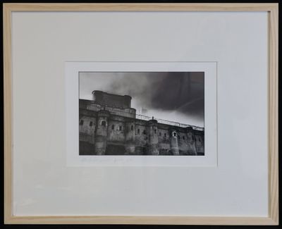 black and white photograph of a building with a clock on top of it