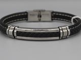 un gros plan sur un bracelet en cuir noir muni d'un fermoir en argent