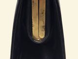a black purse with a gold handle on a white background
