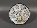a plate with a bird and flowers painted on it