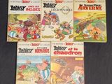 four cartoon books of various ages and sizes on a black surface