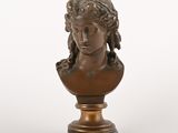 un buste antique en bronze représentant une femme, posé sur un socle en marbre
