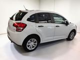 the back end of a white car is parked in a white room
