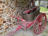 un chariot rouge garé à côté d'un bâtiment en pierre