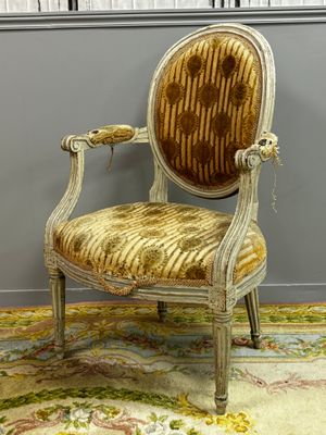 an old chair with a gold velvet upholstered seat