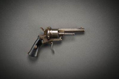 a close up of a gun on a table with a gray background