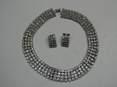 une photo d'un ensemble composé d'un collier et de boucles d'oreilles posé sur une table