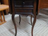 a small table with a drawer on it in a room