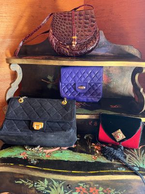 several purses are stacked on top of each other on a shelf