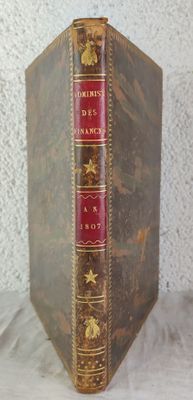 un vieux livre posé sur une table à côté d'un mur blanc