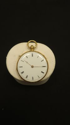 a white clock with roman numerals on it on a black surface